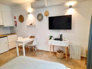 a kitchen with a table and a tv on a wall at Mira Vila Studio - Duna Parque Group in Vila Nova de Milfontes