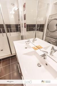 a bathroom with two sinks and a large mirror at T3 Calimero Ax le Régina classé clé vacances 6 couchages in Ax-les-Thermes
