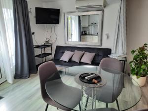 a living room with a glass table and a couch at Apartments Anita in Crikvenica