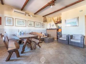sala de estar con mesa de madera y sillas en Casa Ida - Wonderful Vacation en Putzu Idu