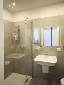 a bathroom with a glass shower and a sink at Przystanek Centrum in Gdynia