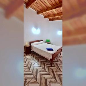 1 dormitorio con 1 cama grande y techo de madera en Alberdi Tempo en Esquel
