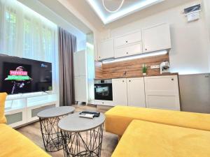 a living room with a yellow couch and a kitchen at The Little Prince studio in Varna City
