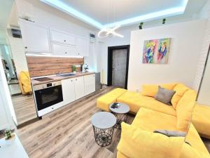 a living room with a yellow couch and a kitchen at The Little Prince studio in Varna City