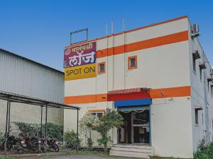 a building with a sign on the side of it at SPOT ON Manav Shree Lodge in Pune