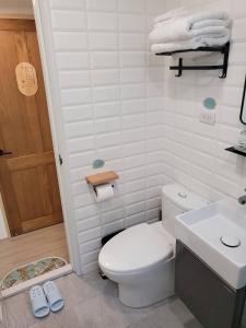 een badkamer met een wit toilet en een wastafel bij Good Stay in Tainan