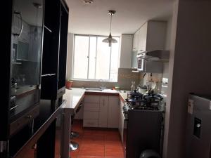 a kitchen with a stove and a sink and a window at Hermoso Duplex en Chorrillos in Lima