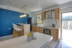 uma cozinha com uma mesa branca e uma parede azul em Villa Silentium Ionia by PosarelliVillas em Argyroupoli