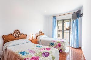sypialnia z dwoma łóżkami i oknem w obiekcie Villa Zoe w mieście Nerja