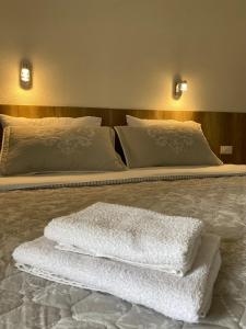 1 dormitorio con 2 camas y toallas blancas. en Pansion Raspudić en Međugorje