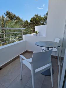 - Balcón con mesa, sillas y silla en Apartamentos Costamar II en Es Pujols