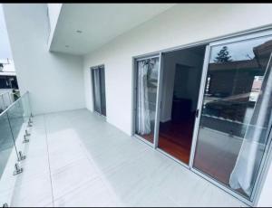 een lege kamer met glazen deuren en een balkon bij A5U3 Hostel in Gold Coast