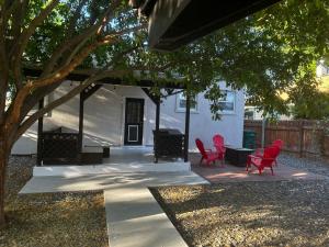 a patio with red chairs and a table under a tree at Cyclist Retreat in downtown Fruita, Colorado in Fruita