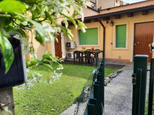 un cortile con tavolo, sedie e recinzione di La casa di Davide con giardino e garage a Verona