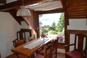 a dining room with a table and a large window at Apart Hotel Bungalows Matute in San Carlos de Bariloche