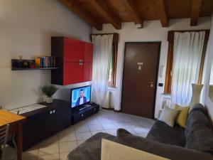 a living room with a couch and a tv at La casa di Davide con giardino e garage in Verona