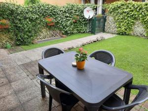 a black table and chairs with a plant on it at La casa di Davide con giardino e garage in Verona