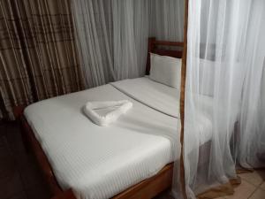 a bed with a white object on top of it at Hotel Sunrise in Nairobi