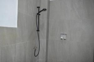 a shower with a shower head in a bathroom at Mahoni Guest House Labuan Bajo in Labuan Bajo