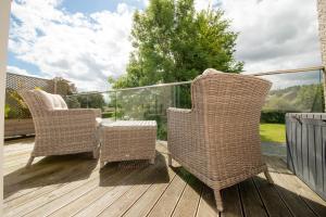 two wicker chairs and a table on a deck at Hawkshead Suites in Hawkshead