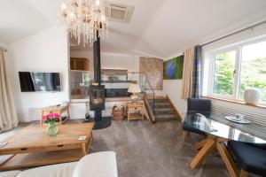 a living room with a dining table and a fireplace at Hawkshead Suites in Hawkshead
