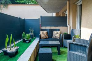 a patio with a blue fence and chairs and plants at the Jungle Loft PARIS-TGV-ORLY confort in Massy
