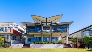 een appartementencomplex met een groot balkon bij Sails on the Beachfront - Exclusive Seaside Home in Anna Bay