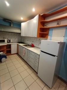 a kitchen with white cabinets and a white refrigerator at Studio nad Kanałem in Kłodzko