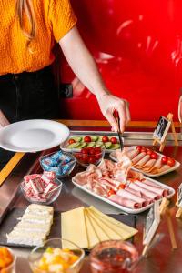 a woman preparing a tray of food on a table at Hôtel Crayon Rouge in Paris