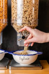 a person is mixing food in a bowl at Hôtel Crayon Rouge in Paris