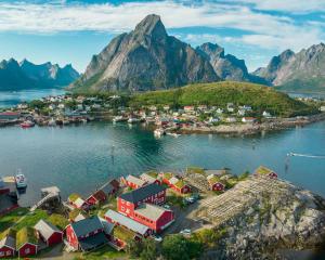 an aerial view of a small town on the water with mountains at Reine Rorbuer - by Classic Norway Hotels in Reine