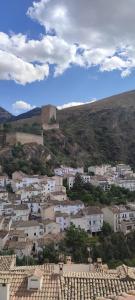 una ciudad con edificios blancos y un castillo a lo lejos en Casa rural mirador de sole, en Cazorla