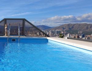 ベニドルムにあるBenidorm Gemelos penthouse with private poolの市街地の建物の上にあるスイミングプール