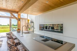 uma cozinha com armários brancos e um grande balcão em Buytenplaats Villa 187 em De Koog