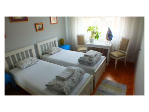 two beds in a room with a table and chairs at B&B Girasole in Novi Sad