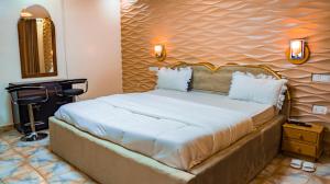 1 dormitorio con 1 cama grande y cabecero de madera en Emerald Villa, en Kigali