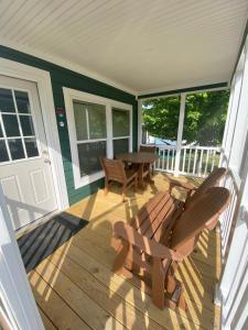 um alpendre com uma mesa e cadeiras numa casa em Jellystone Park at Delaware Beaches em Milford