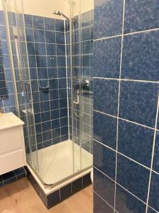 een badkamer met een douche en blauwe betegelde muren bij Ferienwohnung Franzi in Goslar