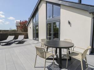 a patio with a table and chairs and a building at Garden House in Amlwch