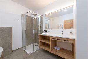 a bathroom with a sink and a shower at Hotel Schönberger in Nussdorf am Attersee