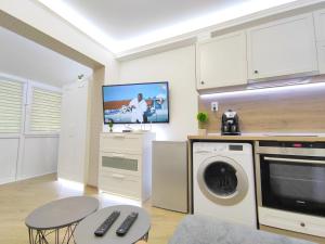 cocina con lavadora y TV en Ally's Place studio en Varna