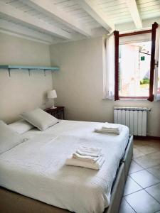 a bedroom with a large white bed with towels on it at Vittoria 19 in Portovenere
