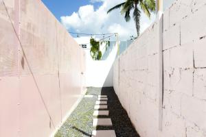 una pared de hormigón con un camino entre ella en TROPICALIA by DW, en San Juan