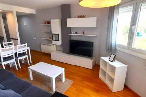 un soggiorno con divano, TV e tavolo di Apartamento Playa Foz a Foz