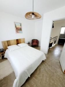 Un dormitorio con una gran cama blanca en una habitación. en Maison de village 4 étoiles avec piscine privee, en Villars