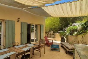Un patio con una mesa y sillas y una sombrilla. en Maison de village 4 étoiles avec piscine privee, en Villars