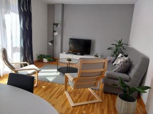 uma sala de estar com um sofá e uma televisão em Adiva Praia Miño em Miño