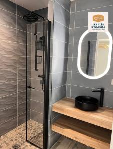 a bathroom with a shower with a sink and a mirror at Le mas contemporain de Dun in Dun-le-Palestel