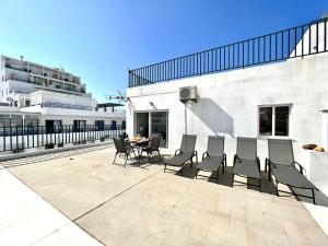 d'une terrasse avec des chaises et une table. dans l'établissement Quarteira Ocean Breeze 1 With Pool by Homing, à Quarteira