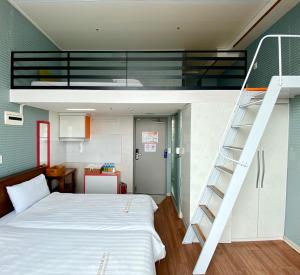 a bedroom with a bunk bed and a ladder next to a bed at Myeongdong Merlin Hotel in Seoul